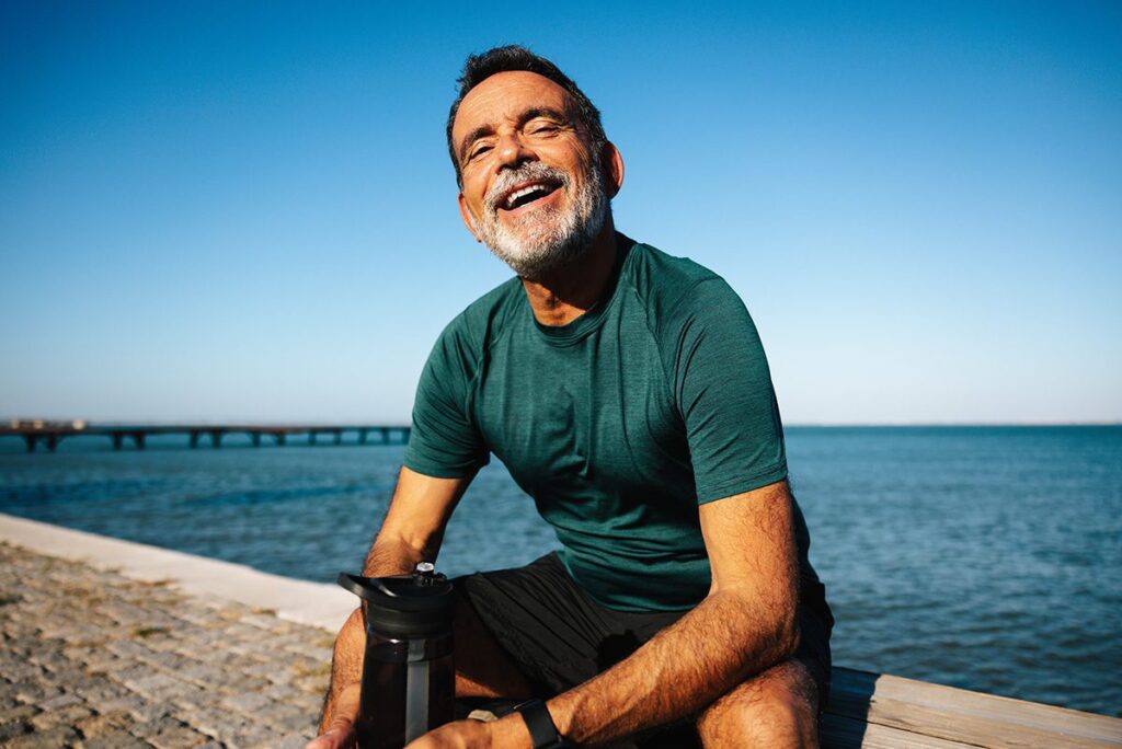 Smiling man enjoying outdoors by a scenic waterfront
